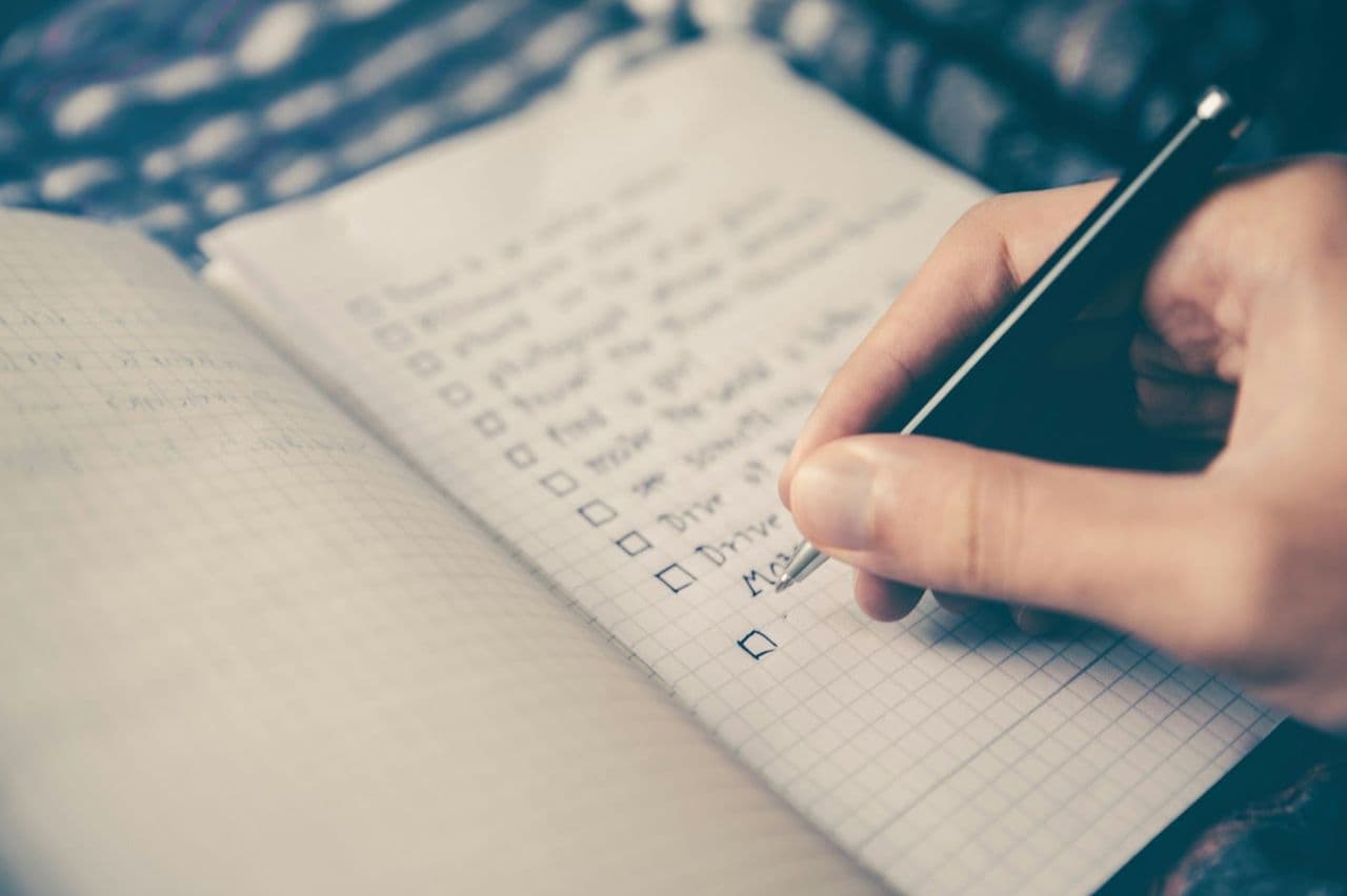 Smartphone mit geöffnetem Google-Unternehmensprofil eines lokalen Betriebs, daneben ein Notizbuch mit handschriftlicher Checkliste