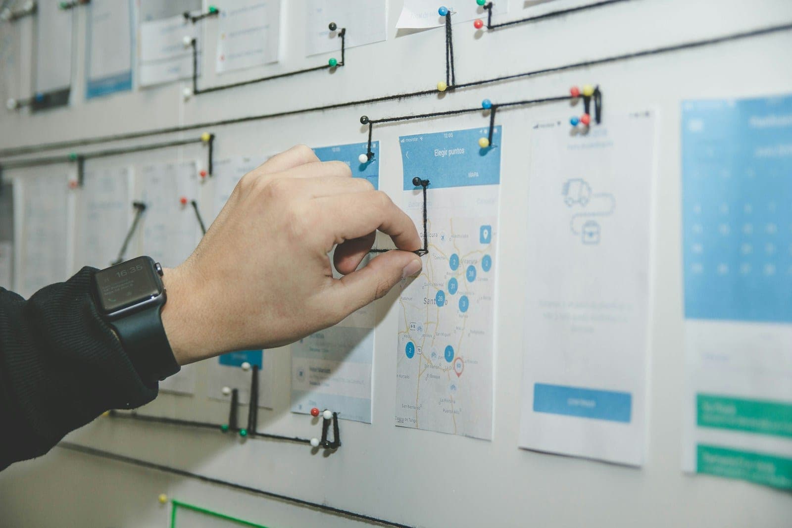 Whiteboard mit einer skizzierten Roadmap: Ziele, Zielgruppen und priorisierte Maßnahmen als Pfad mit nummerierten Etappen, davor ein Tisch mit Laptop und Kaffeetasse