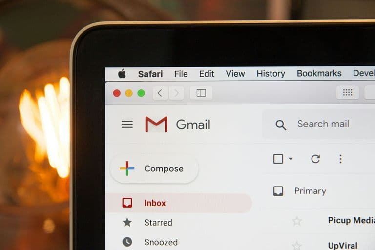 Unternehmer sitzt nachdenklich vor einem Laptop mit geöffneter Firmenwebsite und leerem E-Mail-Postfach