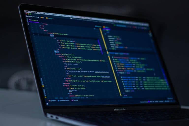Bildschirm mit geöffnetem Quelltext und Browser-Entwicklertools einer Website, daneben handschriftliche Notizen zu Ladezeit und Seitenstruktur