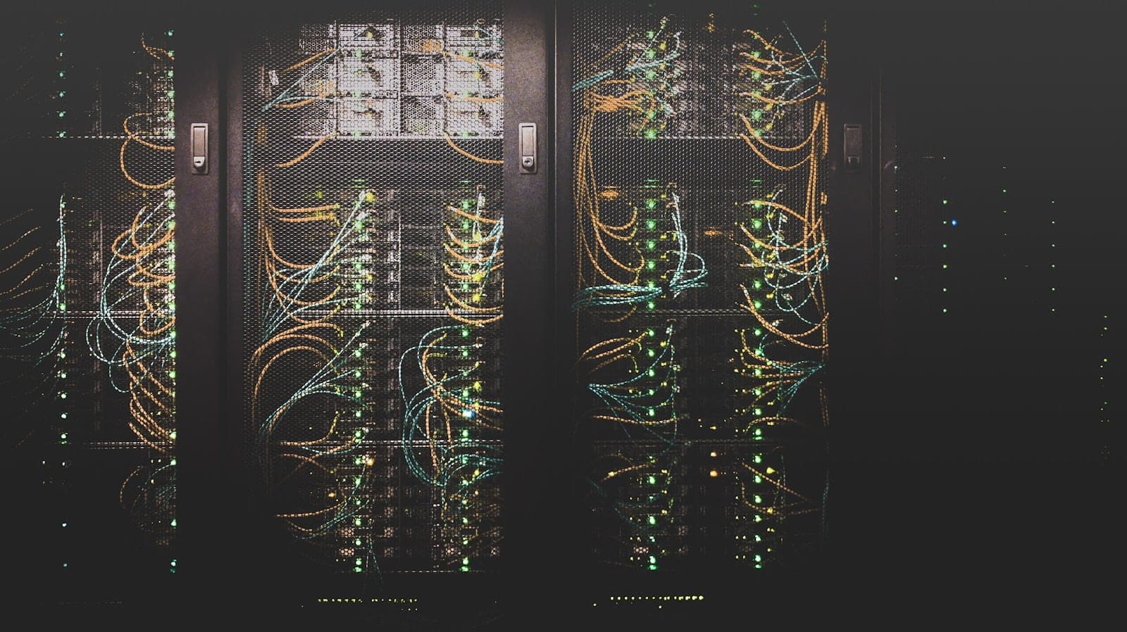 Aufgeräumte Serverschränke in einem Rechenzentrum mit dezenter Beleuchtung, im Vordergrund ein Laptop mit geöffneter Hosting-Verwaltungsoberfläche