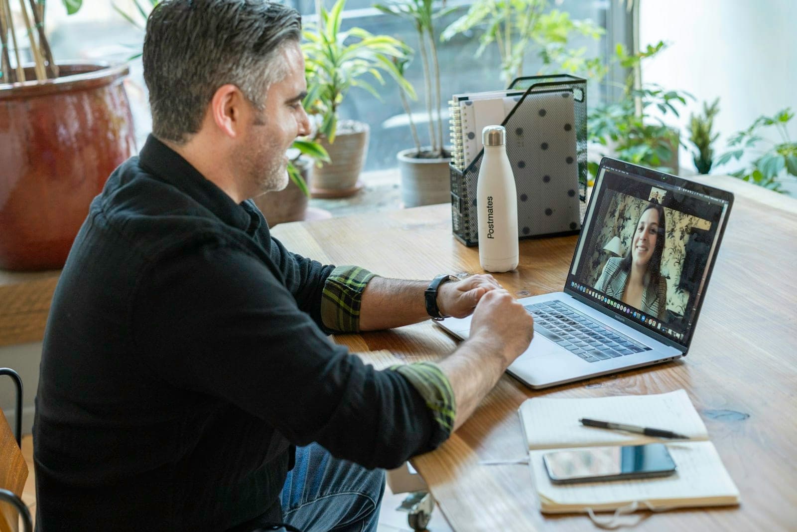 Videogespräch am Laptop in einem hellen Büro – Projektbesprechung zwischen Unternehmer und Webentwickler
